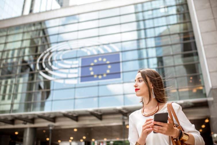 young businesswoman standing with phone near parliament building european union brussel city