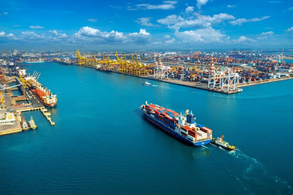 aerial view of freight cargo ship and cargo container in harbor.
